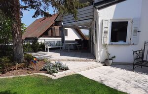 Privatgarten mit Natursteinterrasse, Stufenanlage und überdachtem Sitzbereich mit Pergola